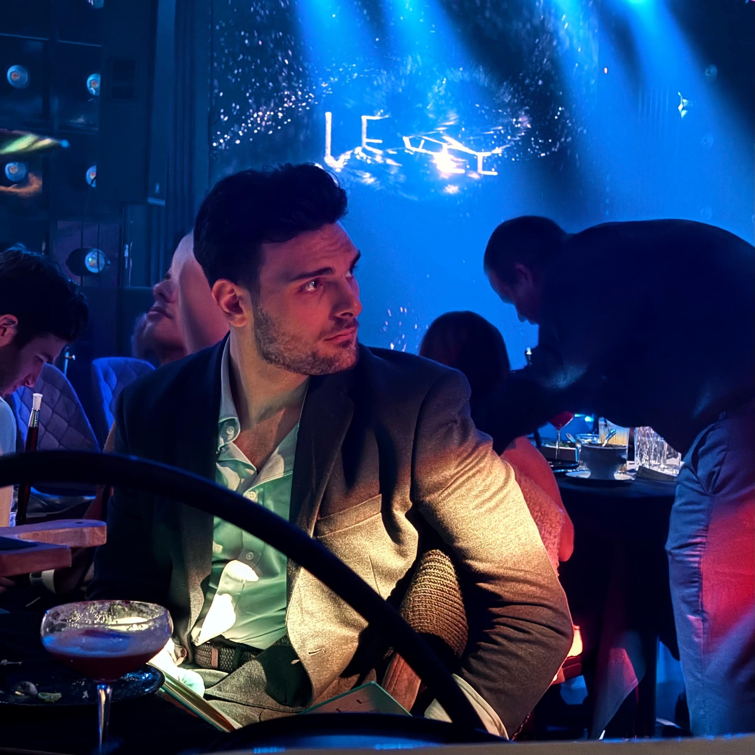 Nadir Kutluozen at a table under blue stage lights